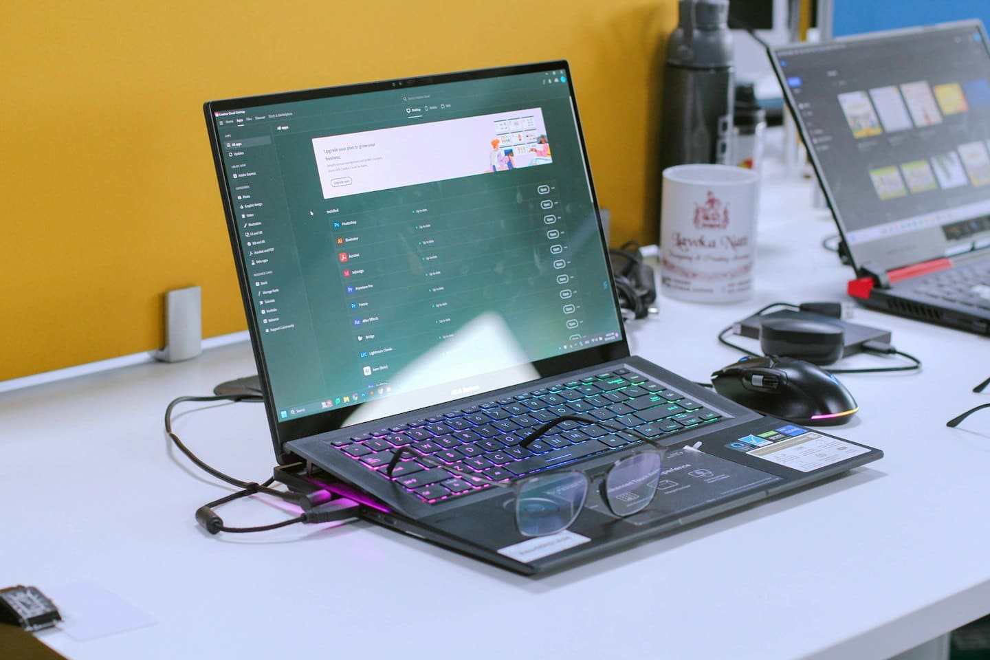 Laptop with software open and glasses on a desk.