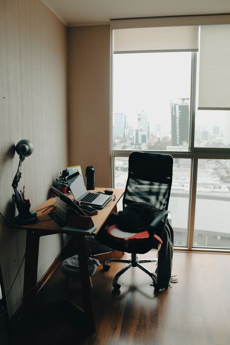Open laptop on a wooden desk in a sunny home office.